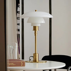 White glass table lamp with a gold finish on a round table