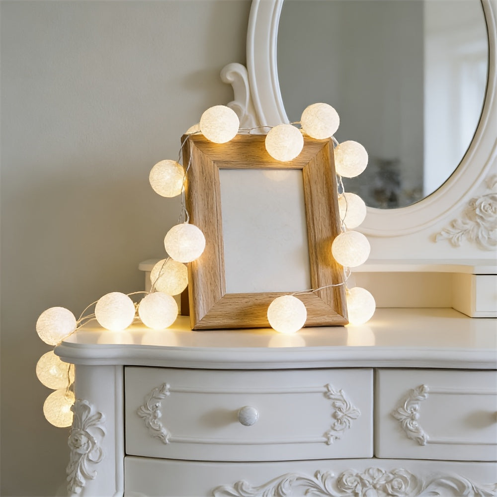 Globe fairy lights framing a round mirror above a dresser.