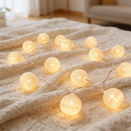 Globe fairy lights spread across a textured blanket.