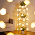 Globe fairy lights illuminating a tall wire plant stand.