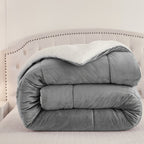 Folded gray plush comforter showing its white fleece underside