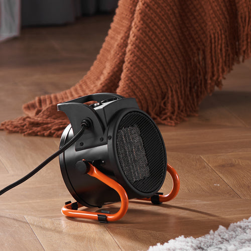 Greenhouse heater on a wooden floor with black body and orange stand.