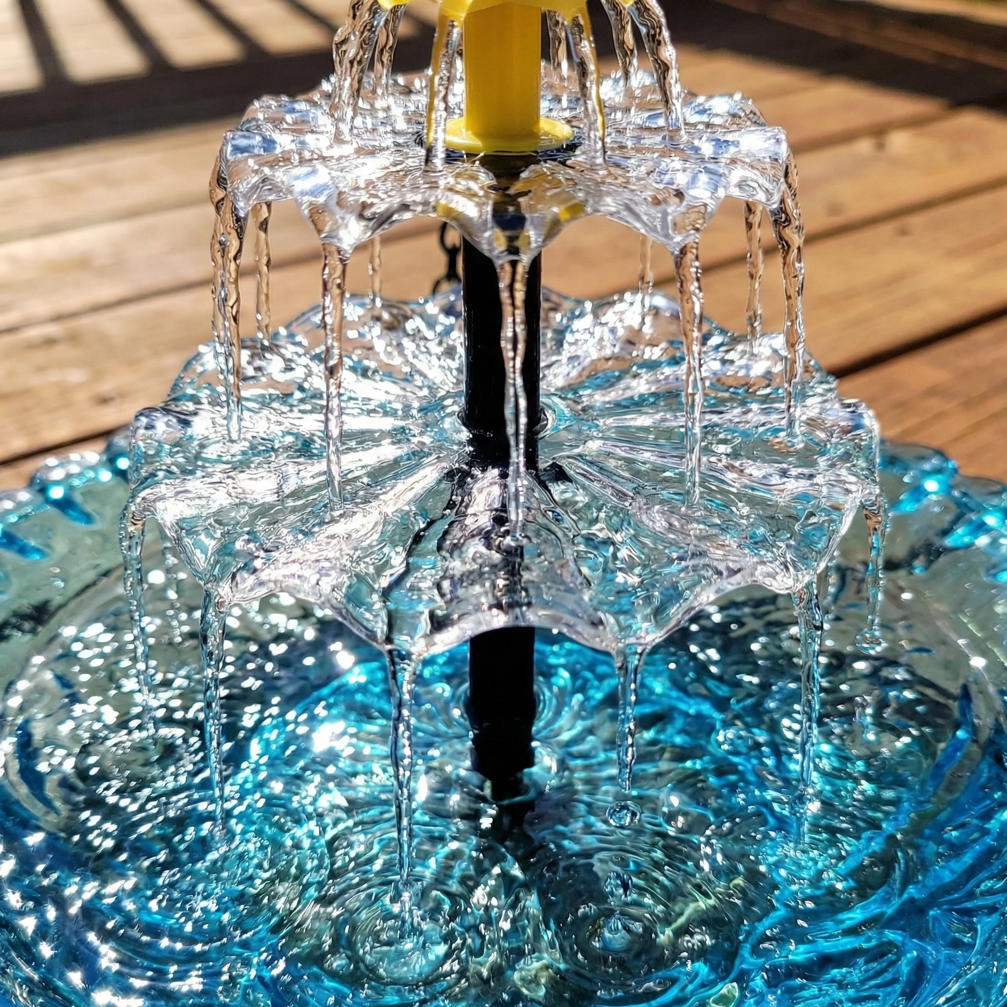 Close view of water flowing through the hanging bird bath fountain.