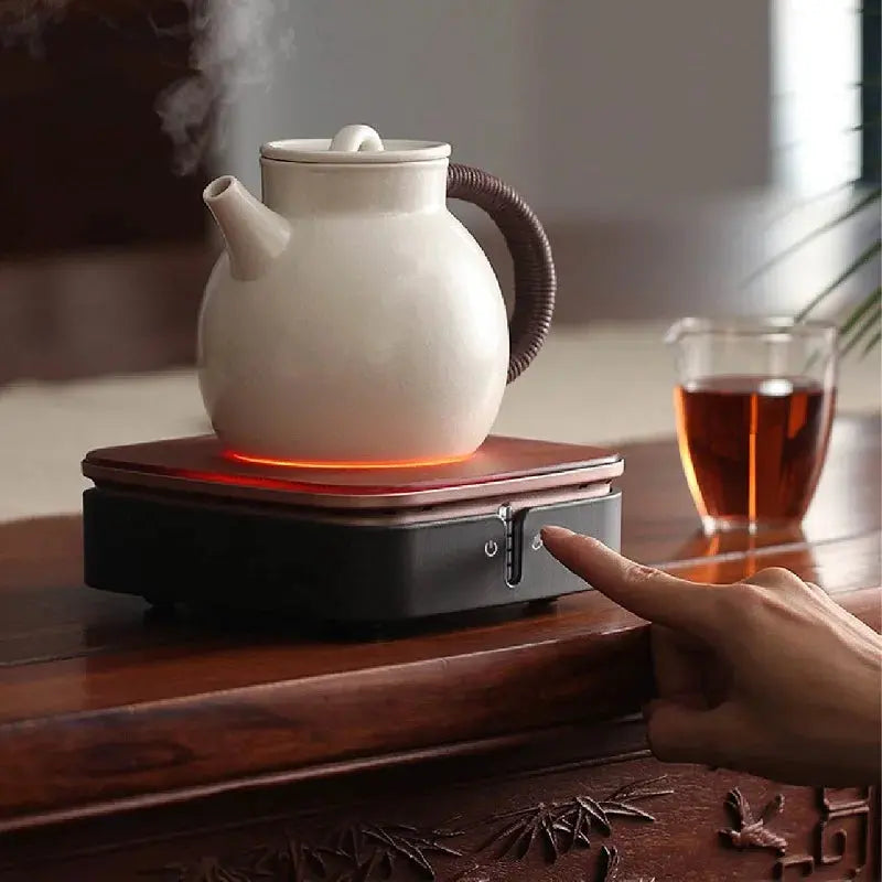 Ceramic hot plate shown heating a teapot on a tabletop
