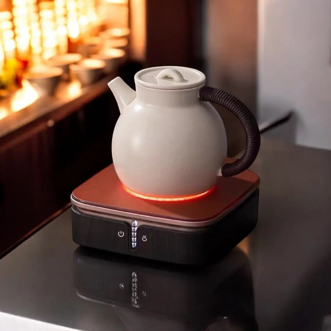 Ceramic hot plate shown heating a teapot on a tabletop