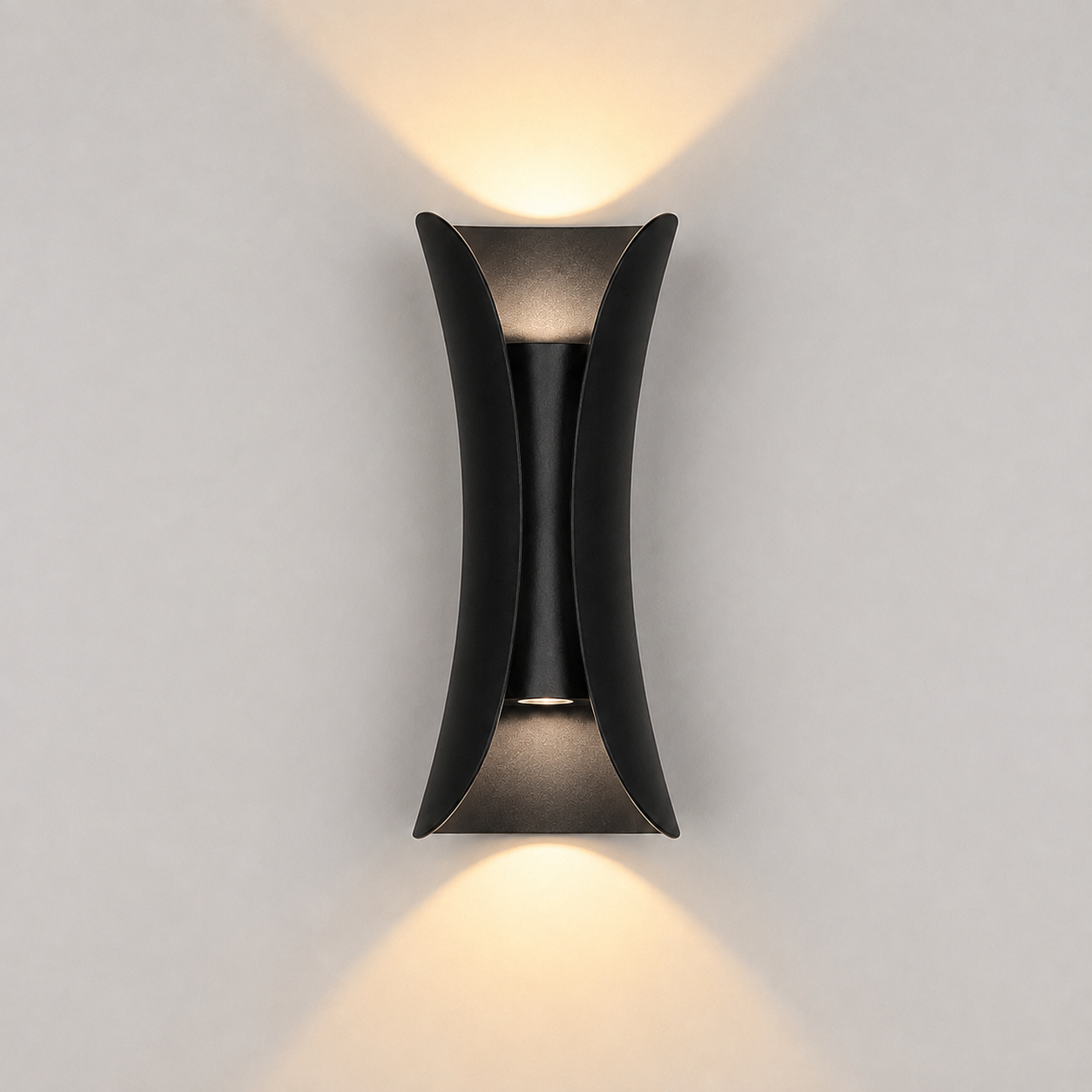Black outdoor wall sconce mounted on a light wall, casting warm light upward and downward.
