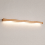 Wooden linear wall sconce glowing against a clean neutral background.