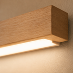 Close-up of a wooden wall sconce glowing against a textured neutral wall.