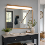 Wooden wall sconce above a wide bathroom mirror with a dark double vanity.