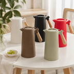 Five insulated carafe colors are arranged on a bright round dining table.