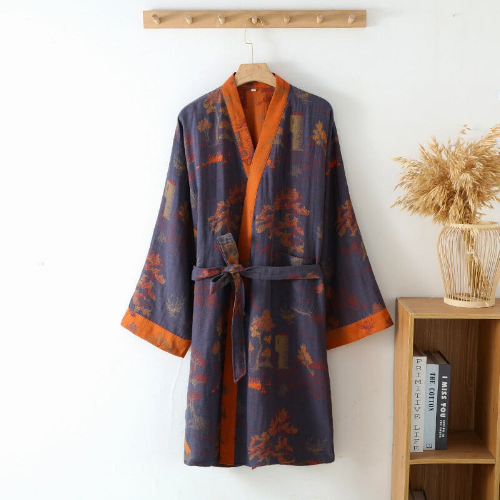Blue cotton kimono bathrobe with orange trim hanging on a wall hook.