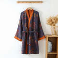 Blue cotton kimono bathrobe with orange trim hanging on a wall hook.