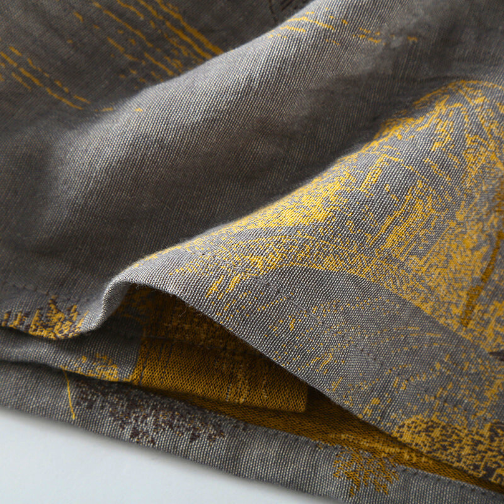 Gray cotton kimono bathrobe fabric showing its yellow woven pattern.