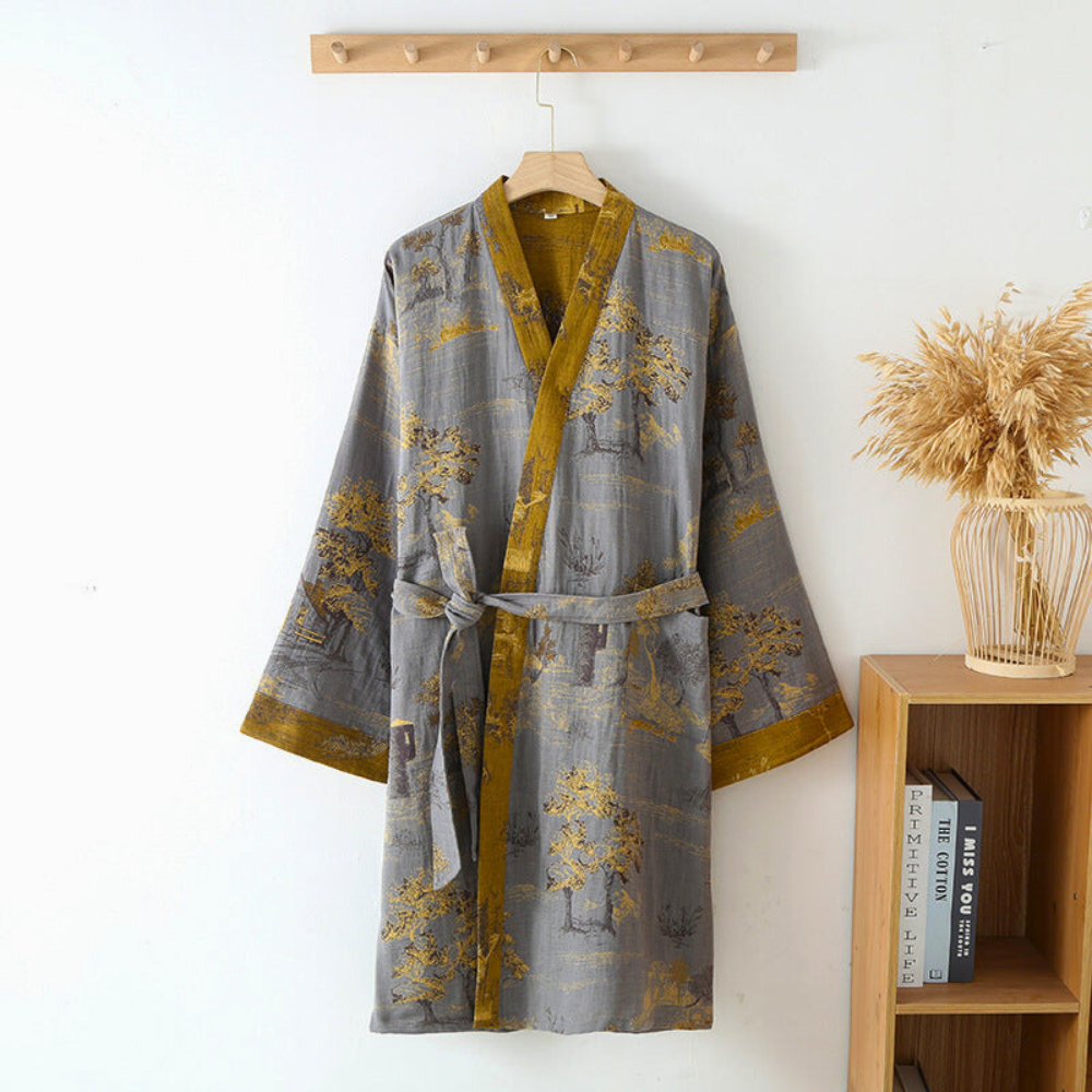 Gray cotton kimono bathrobe with mustard trim hanging on a wall hook.