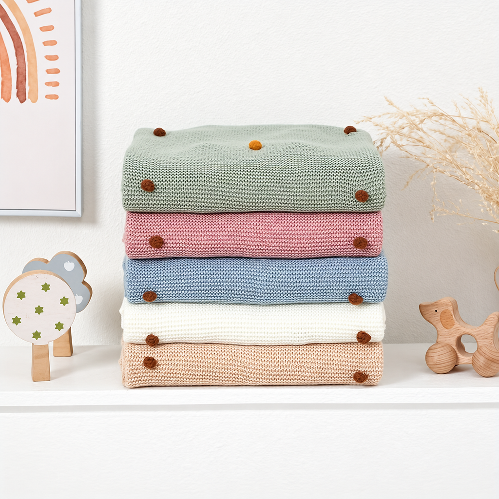 Folded acrylic knit throw blankets showing colorful dot accents in the source color range