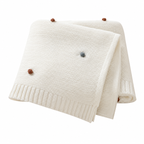 White acrylic knit throw blanket folded on a white background