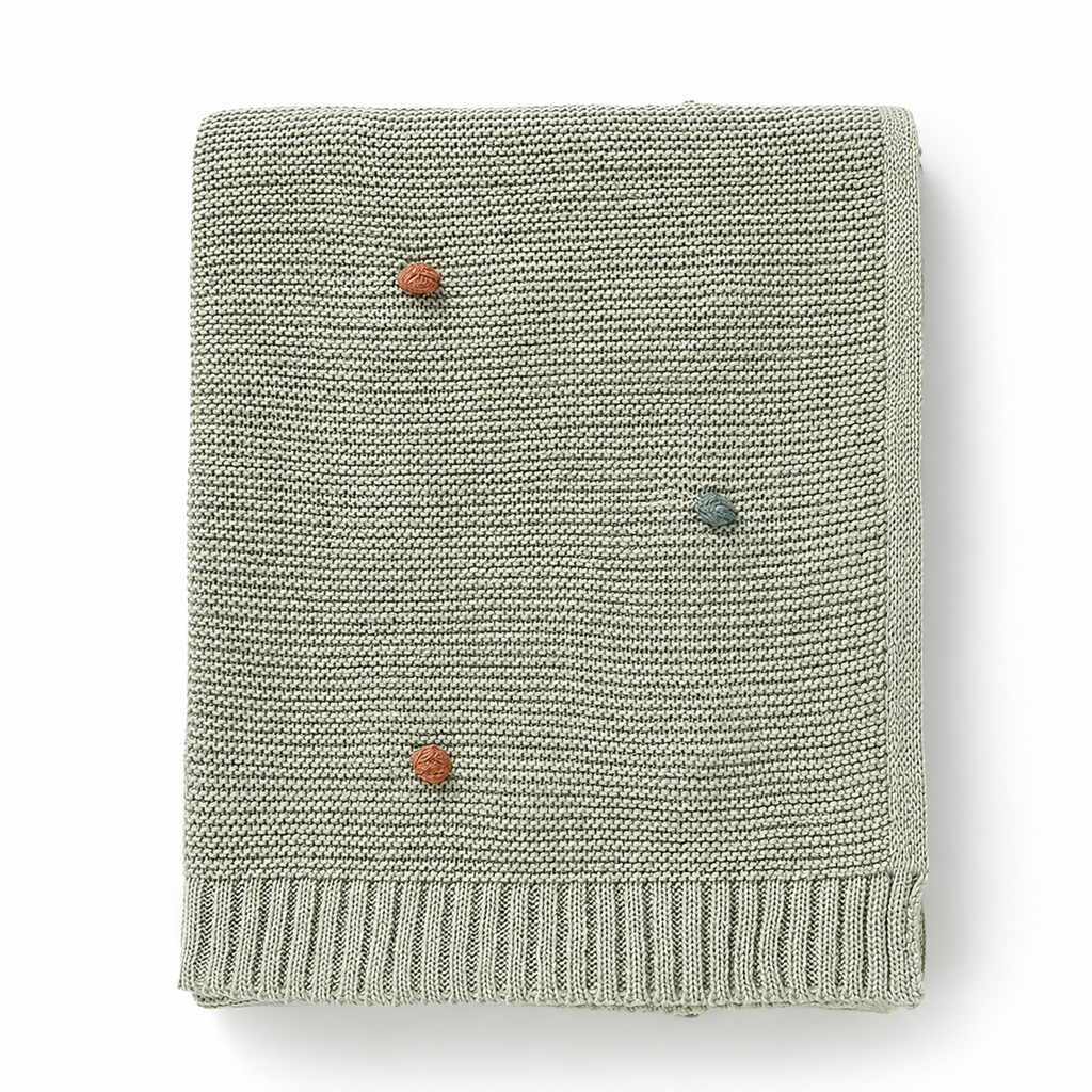 Light green acrylic knit throw blanket showing colored dots and ribbed borders