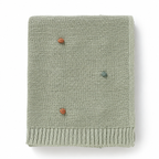 Light green acrylic knit throw blanket showing colored dots and ribbed borders