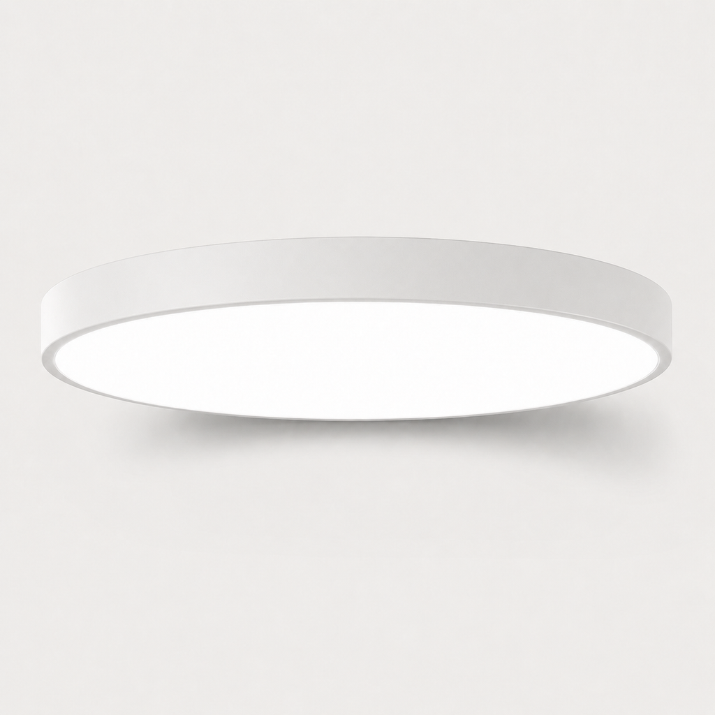 A minimalist, modern circular flush-mount ceiling light in white, shown against a clean, light gray background.