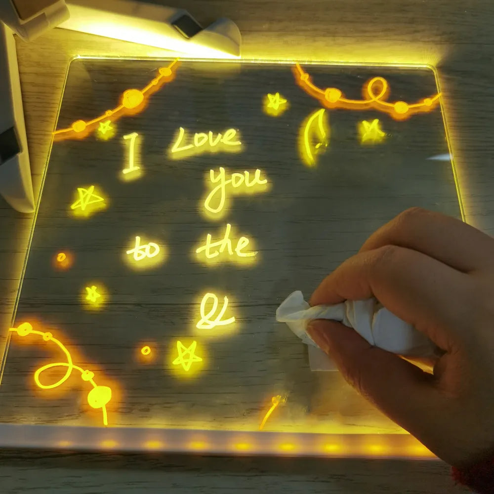 Hand wiping a handwritten message from the illuminated acrylic board