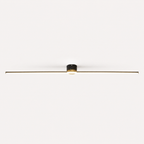 Black linear flush mount ceiling light glowing against a plain off-white background.