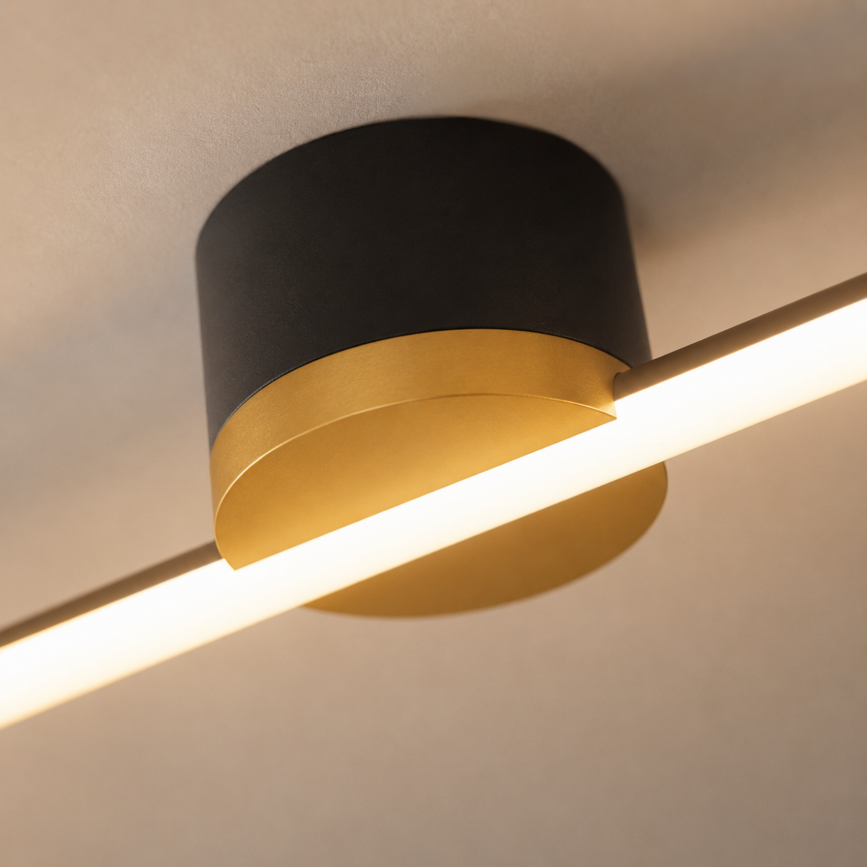 Close-up of the black and gold center mount on the glowing linear flush mount ceiling light.