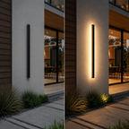 Black wall sconce shown off and glowing warm white on a modern exterior wall beside a glass door.