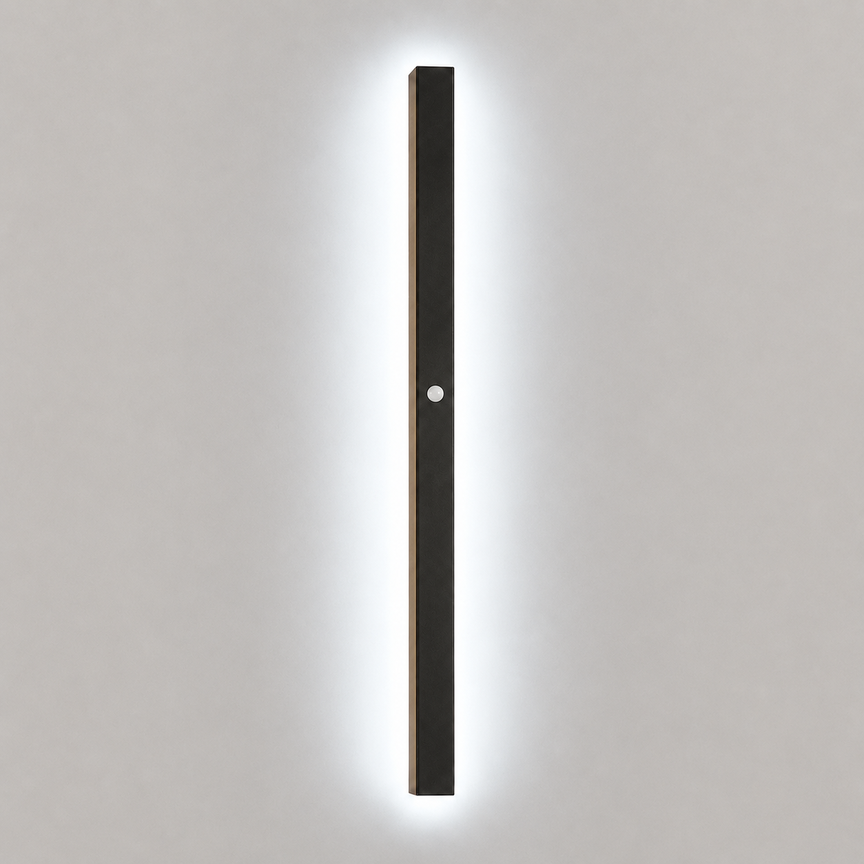 Slim black wall sconce with cool white light with a motion sensor on a pale neutral background.