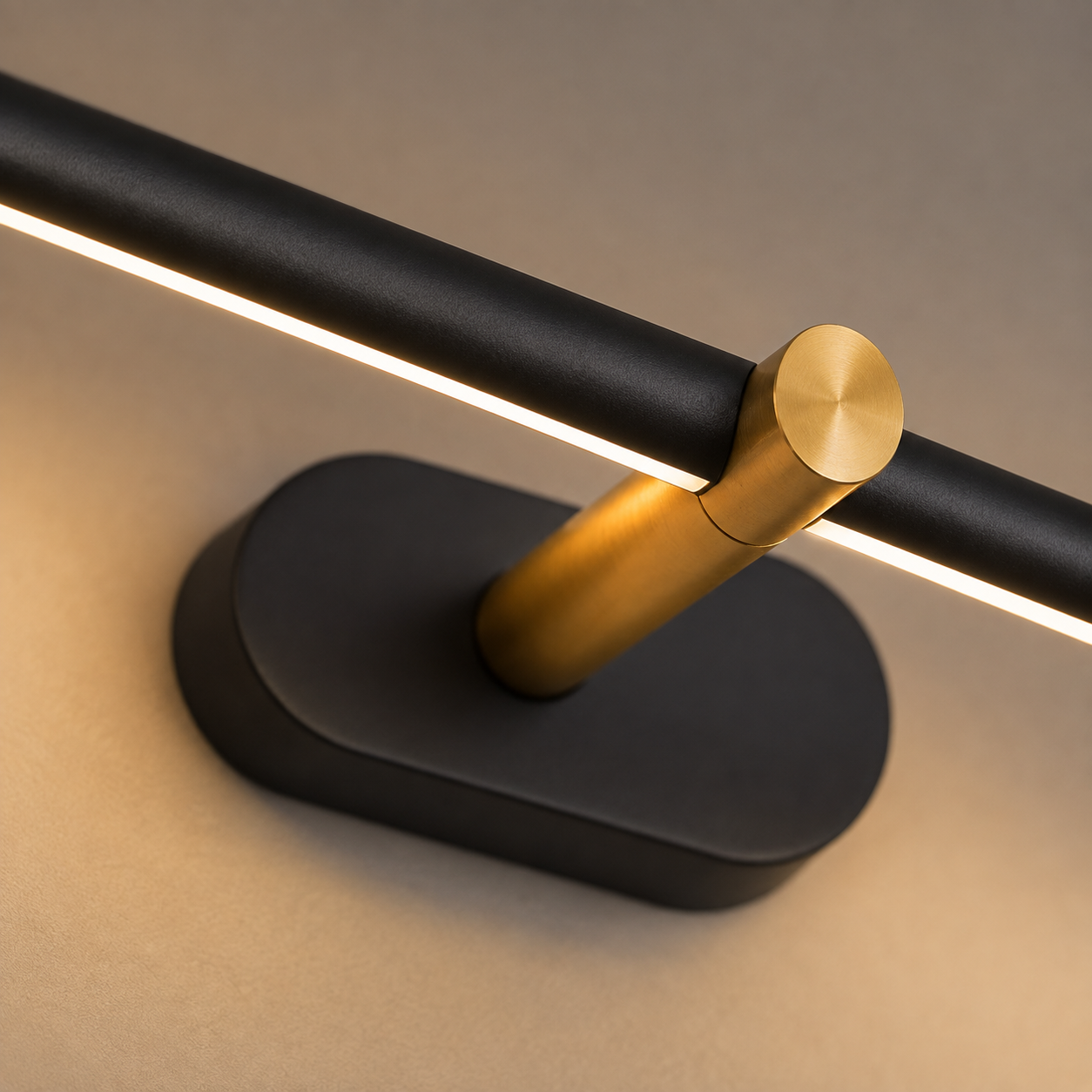 Linear wall sconce close-up showing the black mounting base and gold adjustment joint.