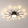 Black starburst ceiling light with radiating LED rods glowing against a neutral studio background.