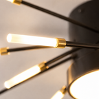 Close-up of a ceiling light showing illuminated LED rods connected to the black center.