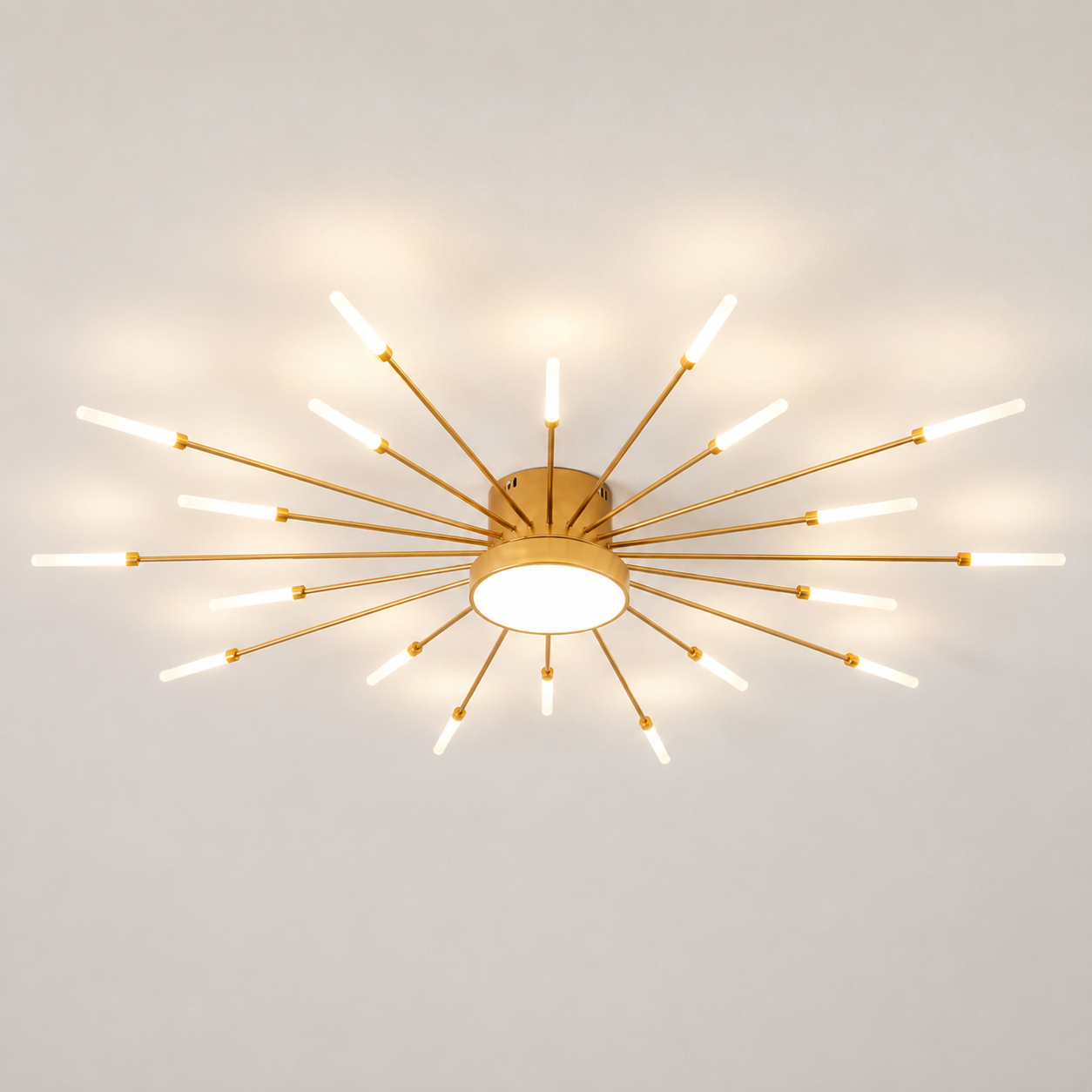 Gold starburst ceiling light with radiating LED rods glowing on a neutral studio background.