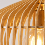Wood pendant light close-up showing curved wooden slats and a glowing bulb.