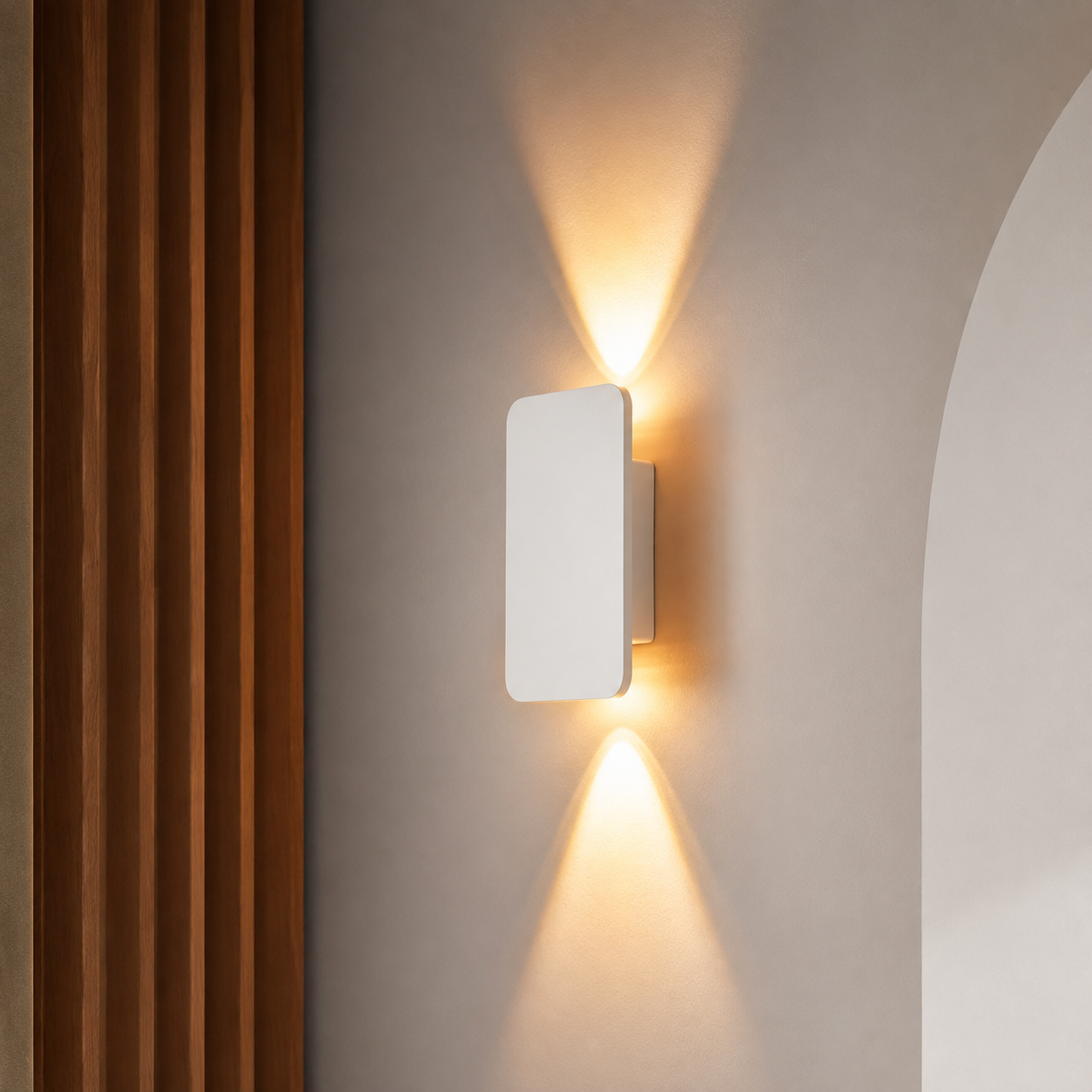 White rectangular wall sconce casting warm upward and downward light beside wood panels.