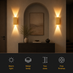 Two gold rectangular wall sconces casting warm light beside an arched mirror and console table.