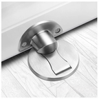 Silver magnetic door stop installed on a pale wood floor.
