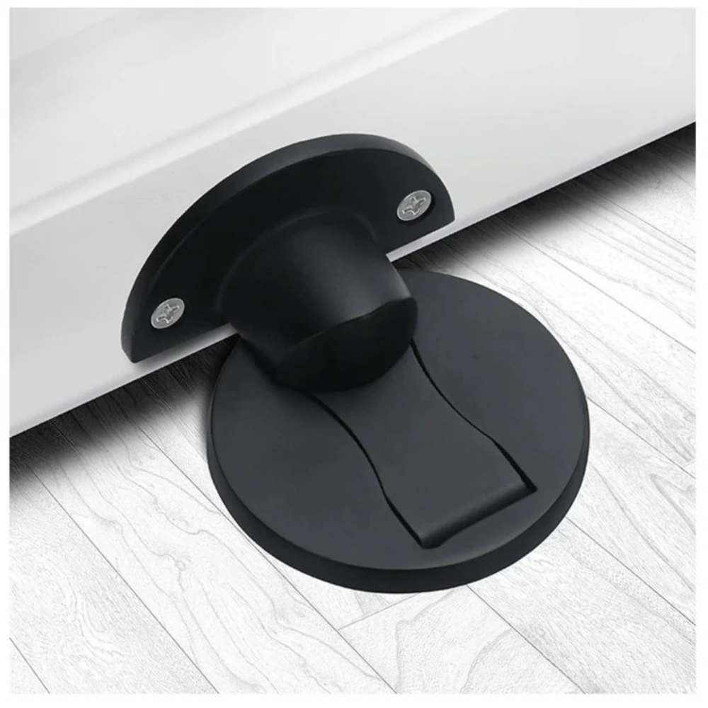 Black magnetic door stop holding a white interior door.