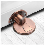 Bronze reddish magnetic door stop mounted on pale flooring.