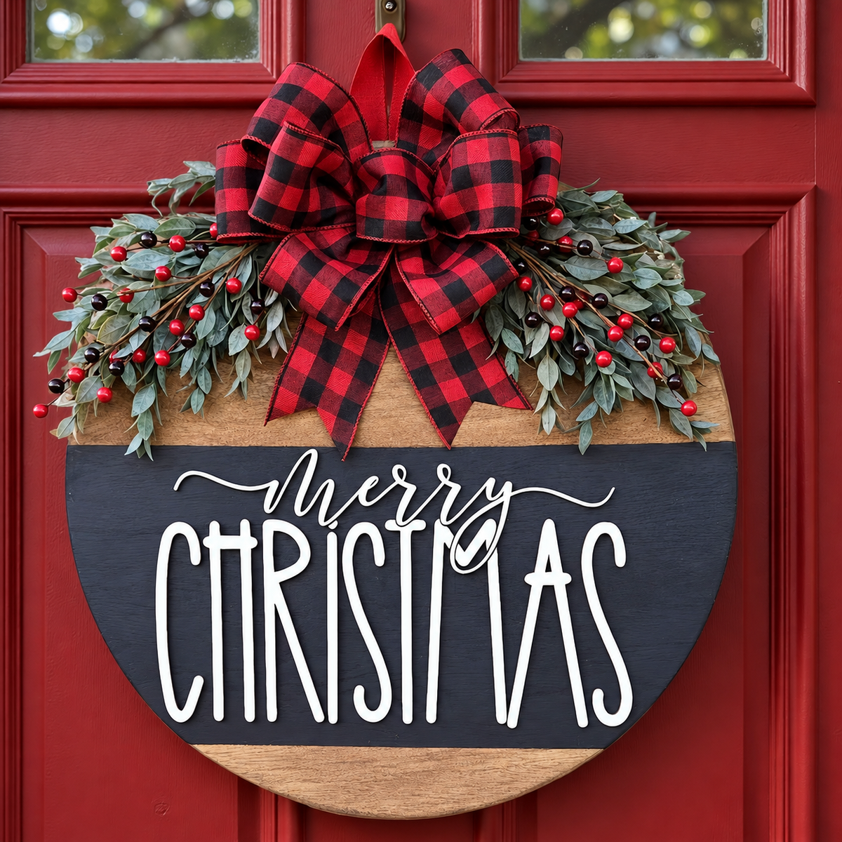 Round Merry Christmas door hanger with red and black plaid bow and artificial greenery on a red door