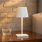 White mini cordless table lamp beside a ribbed glass in an American loft