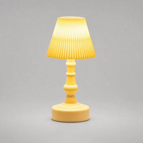 A small yellow table lamp with a pleated fabric shade, a turned wooden-style stem, and a round base, shown against a plain gray studio background.