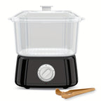 Black mini towel steamer with clear lidded chamber and wooden tongs