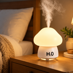 White mushroom humidifier with an illuminated cap releasing mist beside a bed