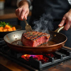 Person searing a steak in a copper frying pan over a gas flame.