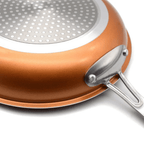 Close-up of a copper pan induction base and riveted stainless steel handle.