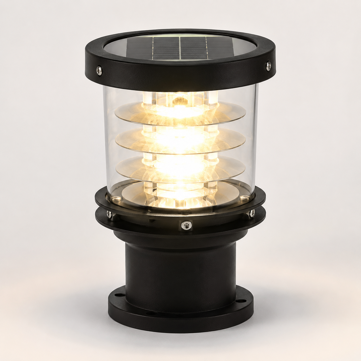 A solar-powered outdoor bollard light with a black metal frame, clear glass shade, and visible solar panel on top, glowing with warm light against a light gray background.