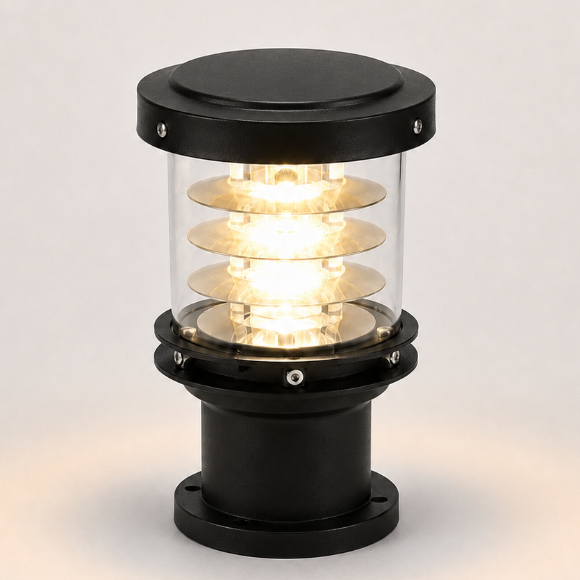 A marine navigation signal lamp with a black metal base and top cap, a clear glass cylinder, and multiple illuminated spiral glass shades showing a warm yellow light, set against a neutral light gray background.