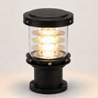 A marine navigation signal lamp with a black metal base and top cap, a clear glass cylinder, and multiple illuminated spiral glass shades showing a warm yellow light, set against a neutral light gray background.