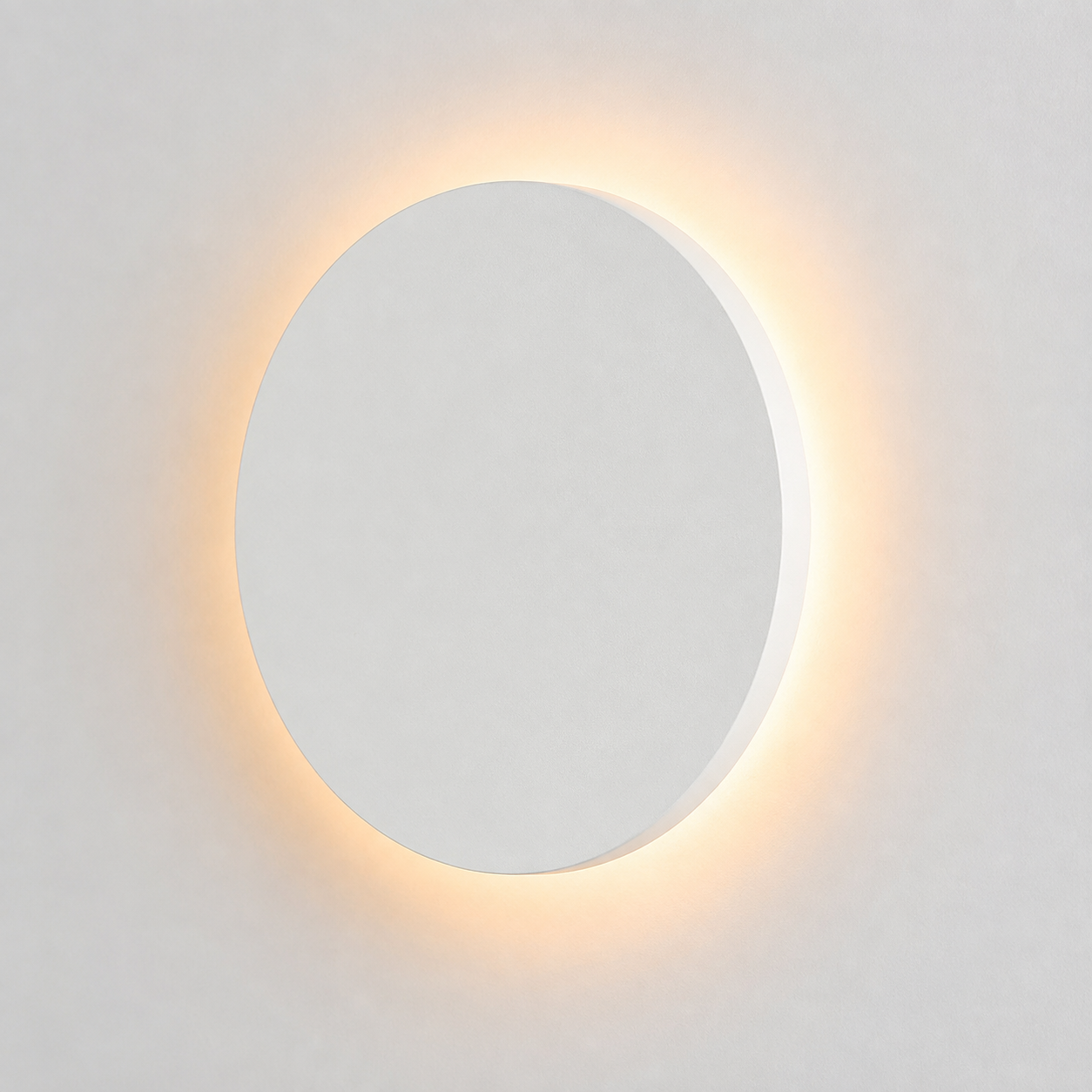 White round outdoor wall light glowing with a warm halo against a plain light background.