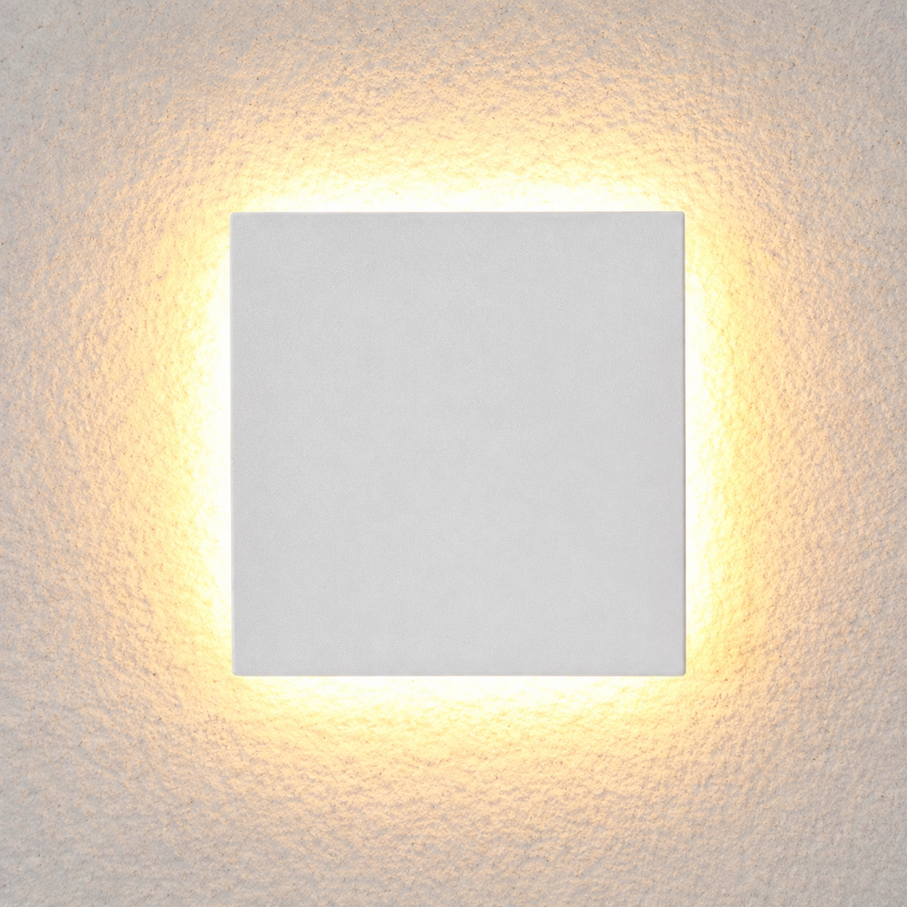 Square white outdoor wall sconce shown at an angle with warm light glowing around the edges.